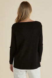 A model wearing the Cable Mini Jumper in colour Black (Black), from the back