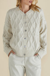 A model wearing the Celene Knit Cardigan in colour Cream, from the front, cropped image