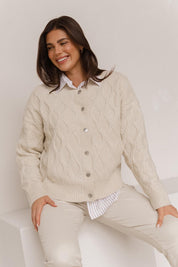 A model wearing the Celene Knit Cardigan in colour Cream, from the front, showing the whole outfit