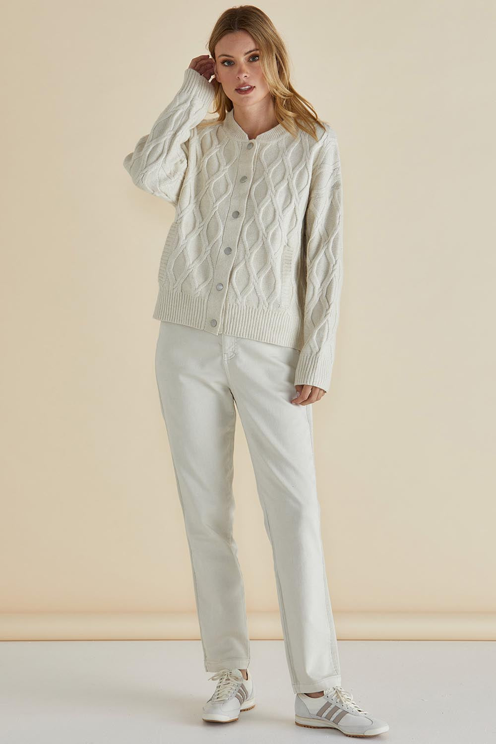 A model wearing the Celene Knit Cardigan in colour Cream, from the front, showing the whole outfit