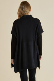 A model wearing the Paige Cotton Blend Poncho in colour Black (Black), from the back