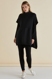 A model wearing the Paige Cotton Blend Poncho in colour Black (Black), from the front, showing the whole outfit