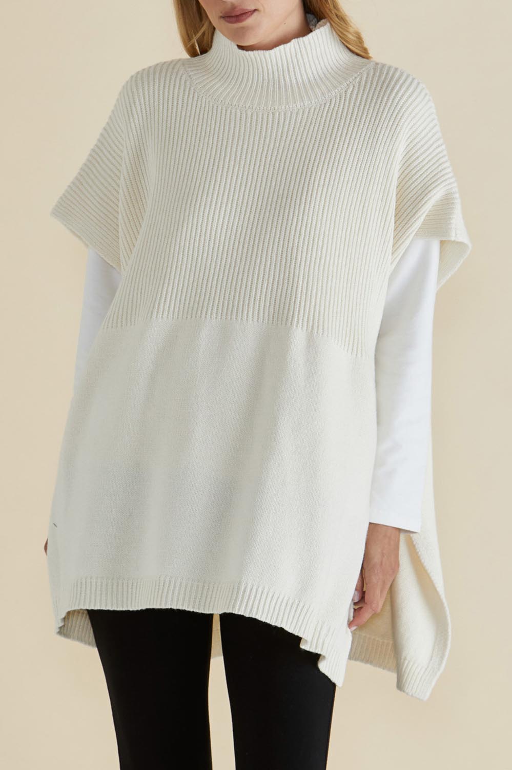 A model wearing the Paige Cotton Blend Poncho in colour Oat, from the front, cropped image