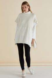 A model wearing the Paige Cotton Blend Poncho in colour Oat, from the front, showing the whole outfit