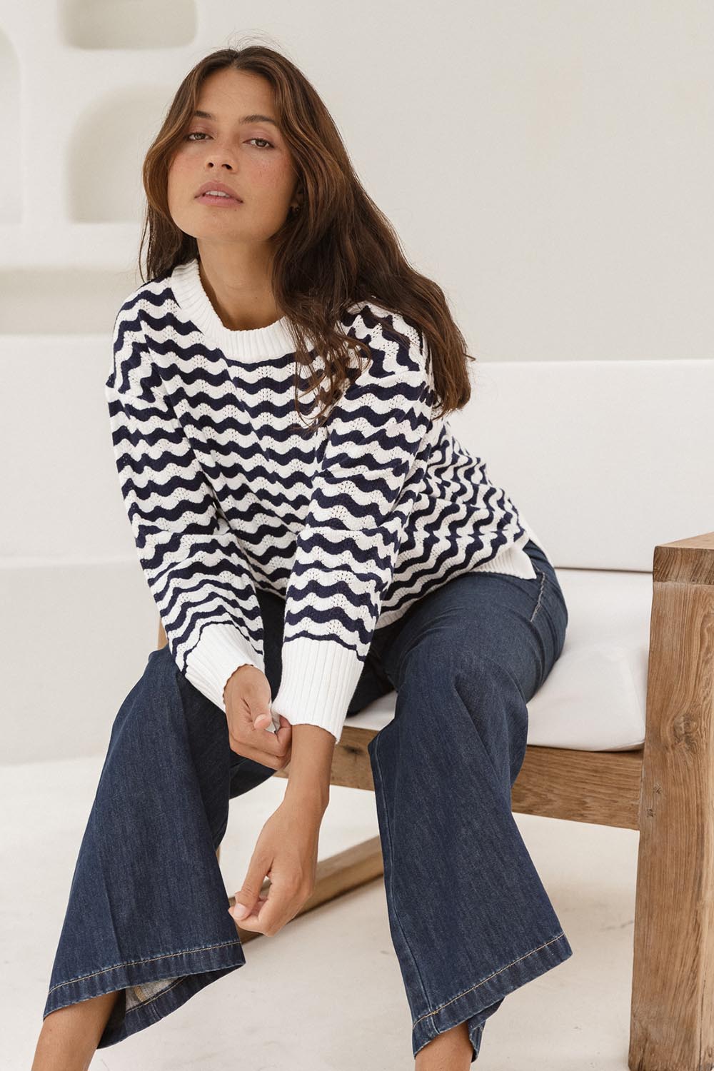 A model wearing the Ember Cotton Knit Jumper in colour Navywave (Blue), from the front, showing the whole outfit