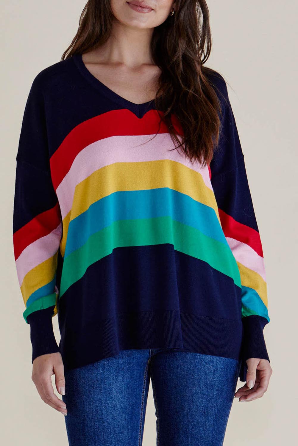A model wearing the Mimi Sweater in colour Rainbow (Blue), from the front, cropped image
