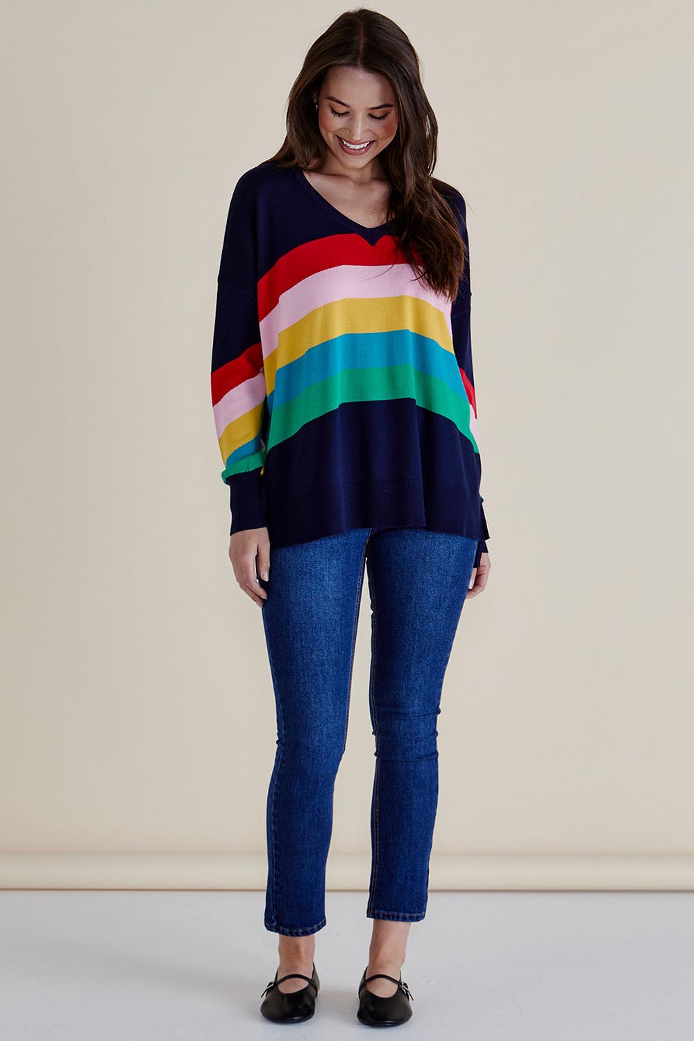 A model wearing the Mimi Sweater in colour Rainbow (Blue), from the front, showing the whole outfit