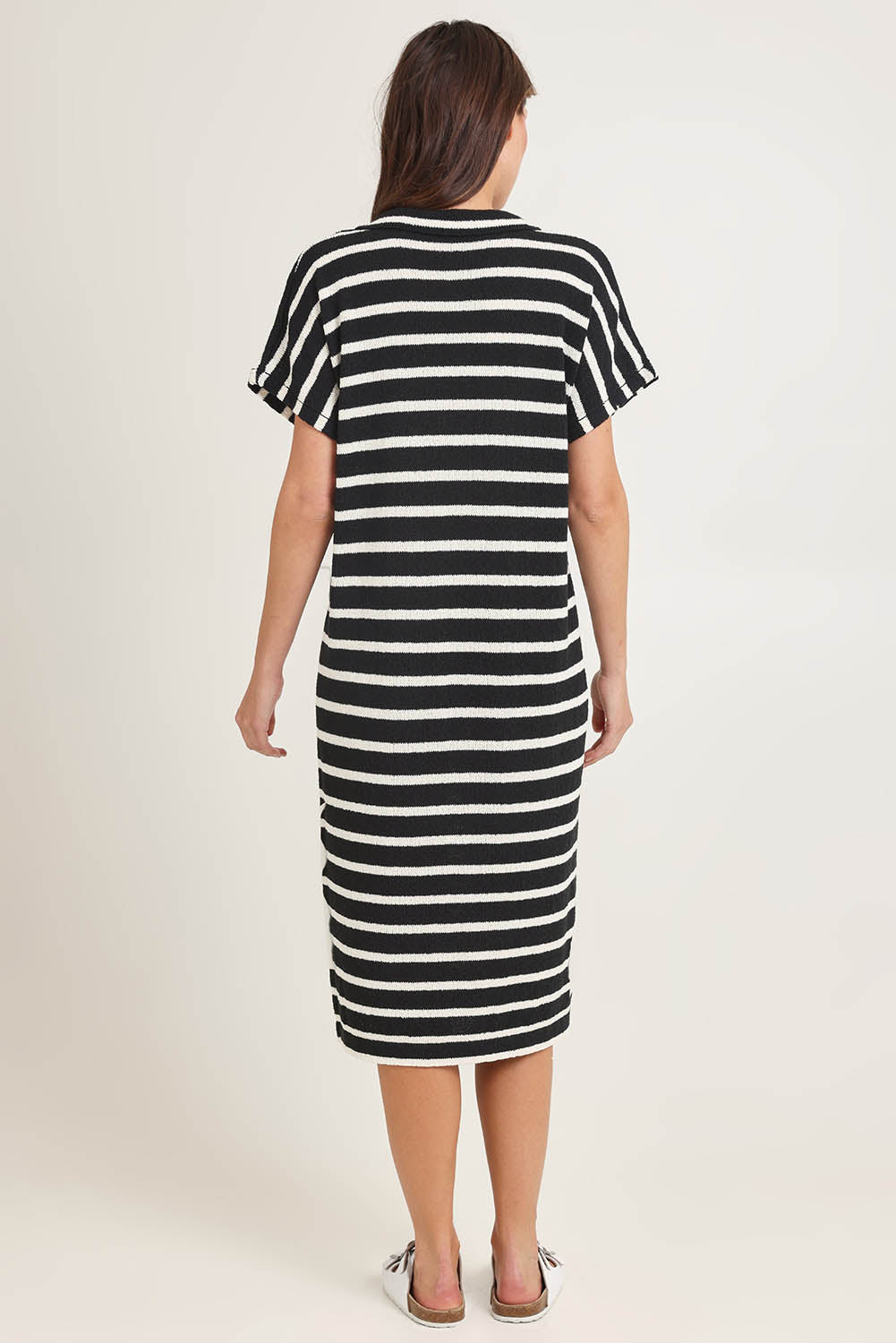 Model Madeline wearing size 10 of the Bradford Knit Polo Dress in colour Creamblk (Black), from the back
