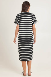 Model Madeline wearing size 10 of the Bradford Knit Polo Dress in colour Creamblk (Black), from the back