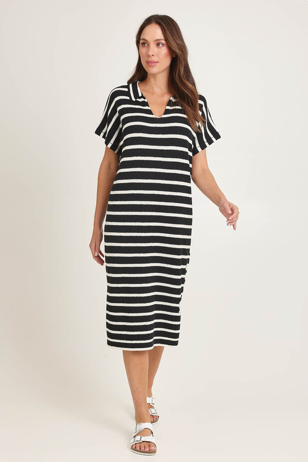 Model Madeline wearing size 10 of the Bradford Knit Polo Dress in colour Creamblk (Black), from the front, showing the whole outfit