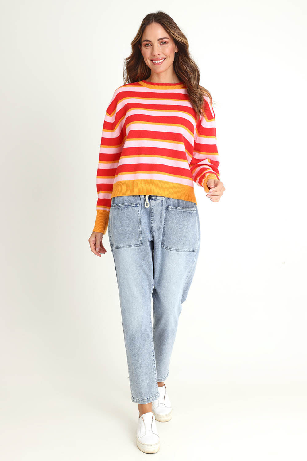 Model Madeline wearing size 10 of the Leonie Knit Sweater in colour Redpink (Red), from the front, showing the whole outfit