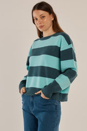 A model wearing the Leonie Knit Sweater in colour Tealblue (Blue), from the front, cropped image