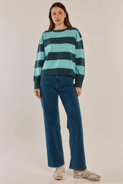 A model wearing the Leonie Knit Sweater in colour Tealblue (Blue), from the front, showing the whole outfit