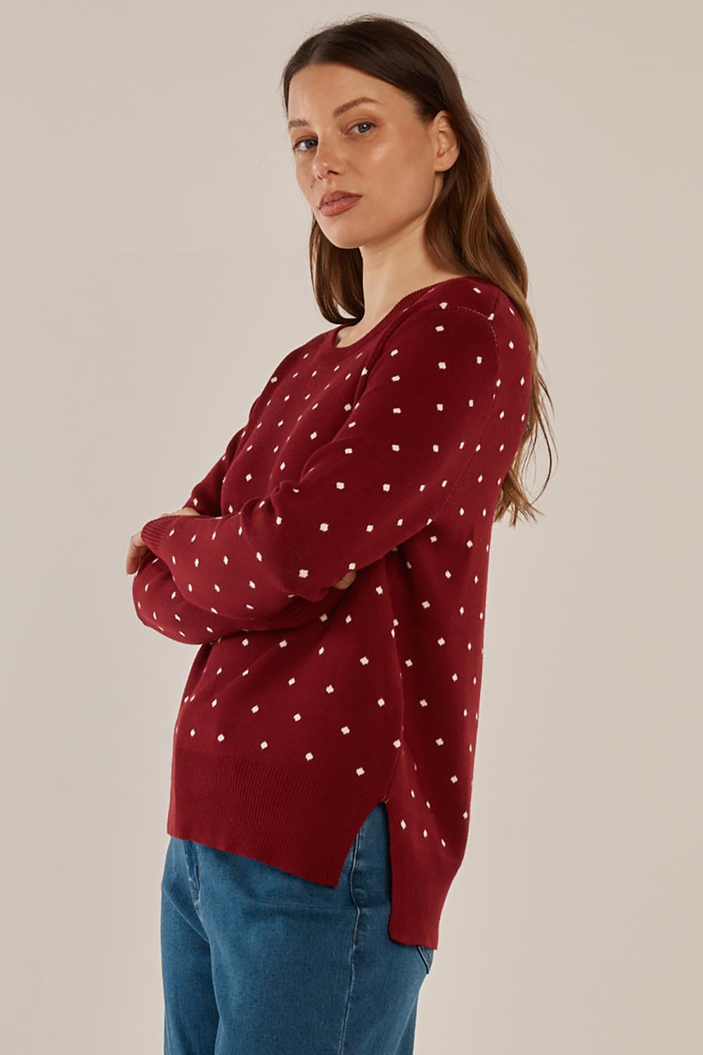 A model wearing the Louis Sweater in colour Burgandy (Red), from the front, cropped image