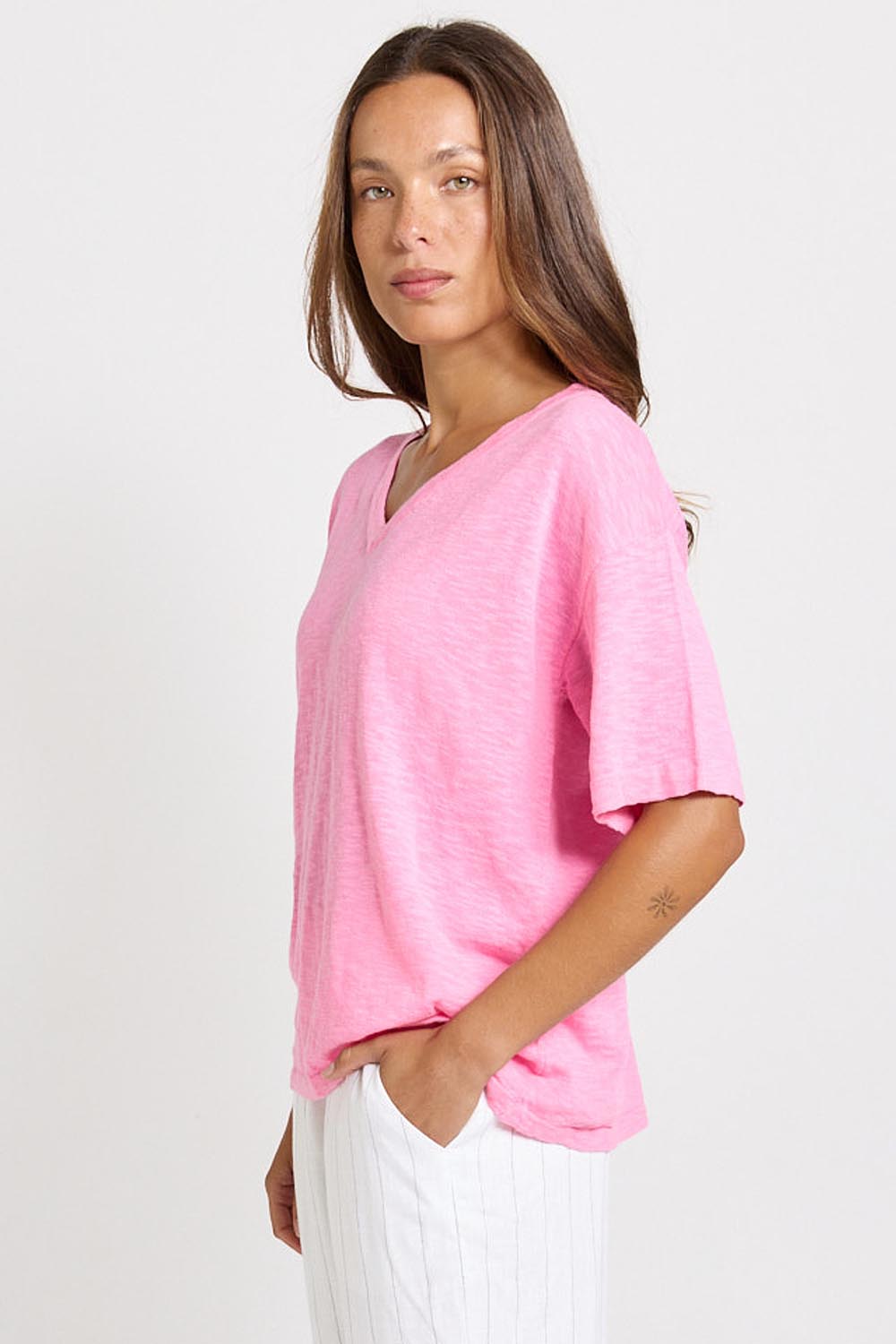 Model Genericm wearing size sample of the Aries V-Neck Sweater Tee – Pink in colour Pink, from an angle