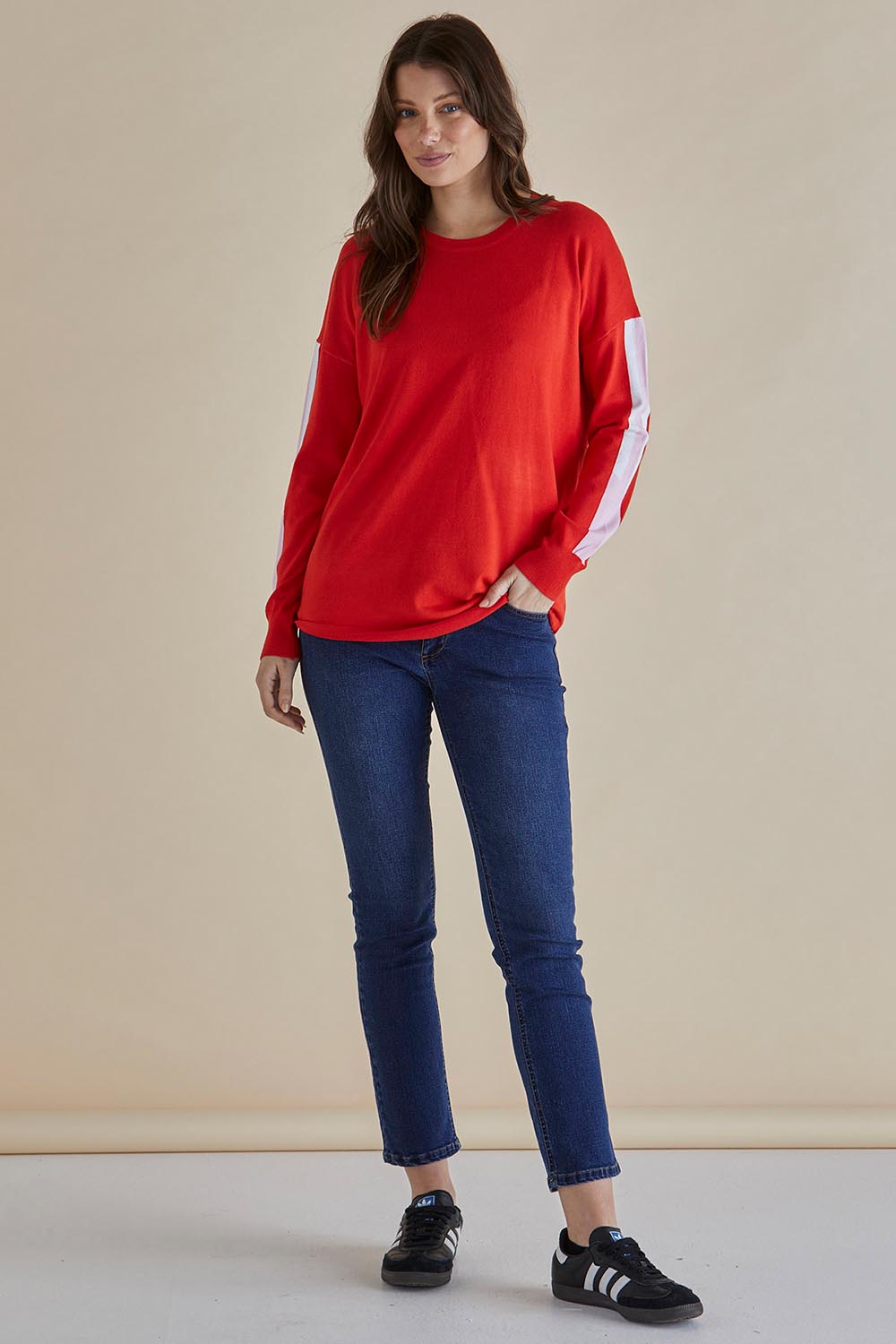 A model wearing the Sophie Knit Jumper in colour Red (Red), from the front, showing the whole outfit