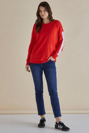 A model wearing the Sophie Knit Jumper in colour Red (Red), from the front, showing the whole outfit