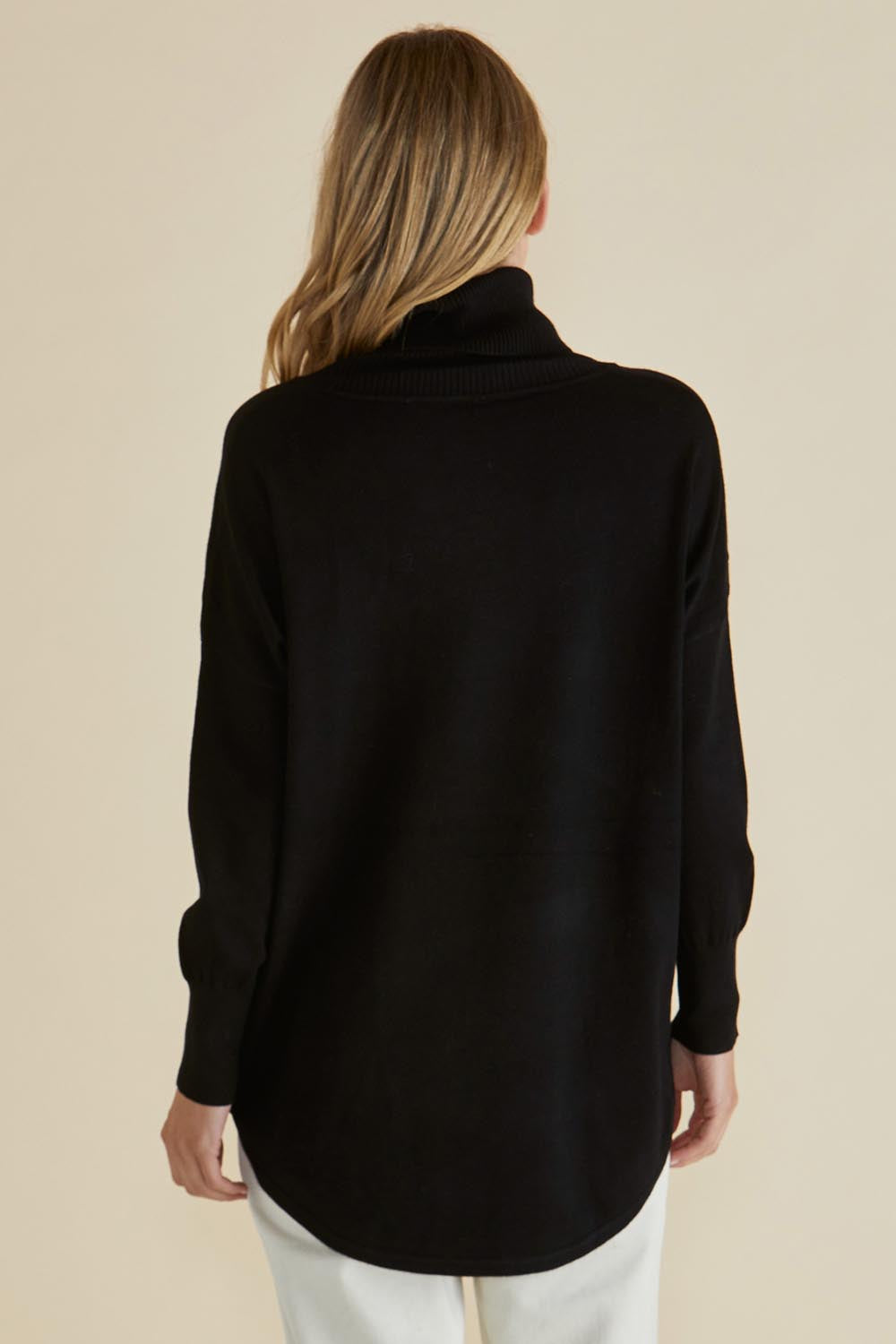 A model wearing the Fleur Roll Neck Jumper in colour Black (Black), from the back