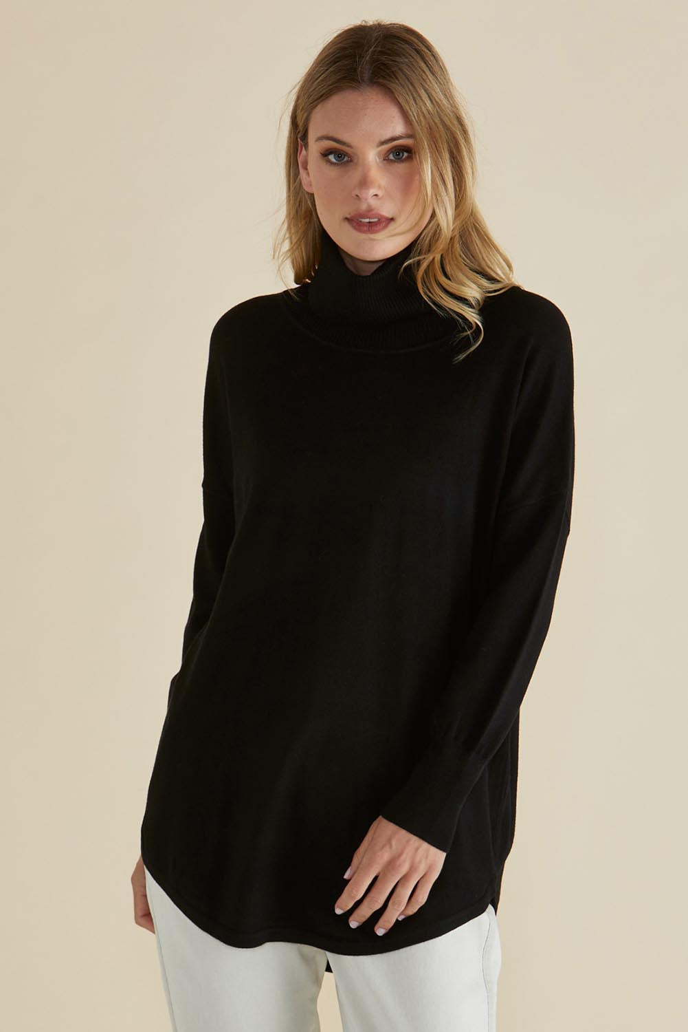 A model wearing the Fleur Roll Neck Jumper in colour Black (Black), from the front, cropped image