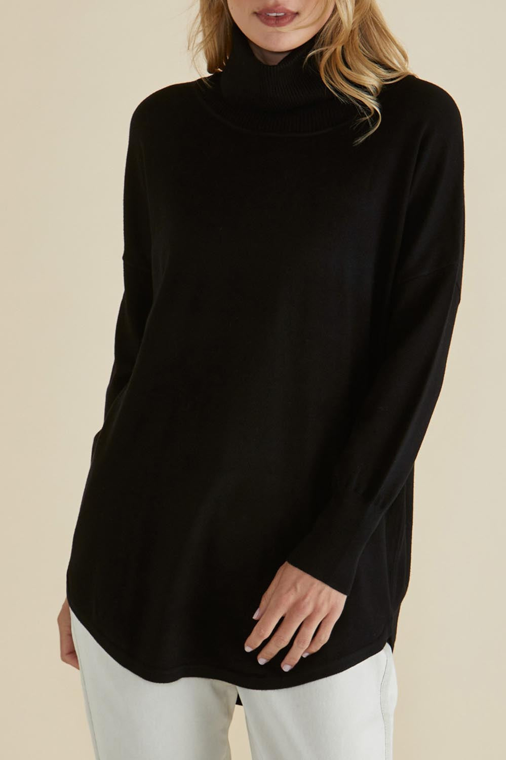 A model wearing the Fleur Roll Neck Jumper in colour Black (Black), from the front, cropped image