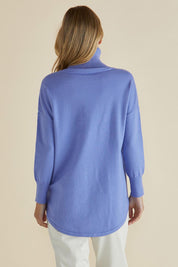 A model wearing the Fleur Roll Neck Jumper in colour Powderblue (Blue), from the back