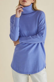 A model wearing the Fleur Roll Neck Jumper in colour Powderblue (Blue), from the front, cropped image