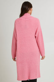 Model Madeline wearing size S of the Mia Cardigan in colour Floss (Pink), from the back