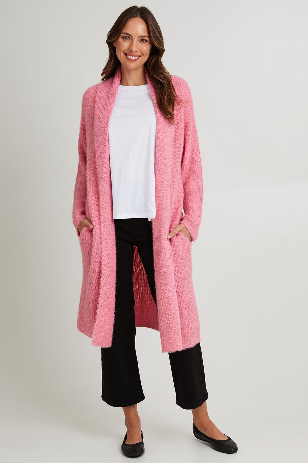 Model Madeline wearing size S of the Mia Cardigan in colour Floss (Pink), from the front, showing the whole outfit