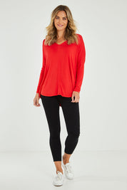 Model Alice wearing size 10 of the Oslo Top in colour Redalert (Red), from the front, showing the whole outfit