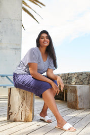 A model wearing the Nadia Skirt in colour Navy (Blue), from the front, showing the whole outfit