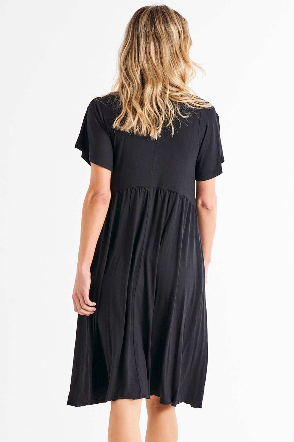 A model wearing the Donna Dress in colour Black (Black), from the back