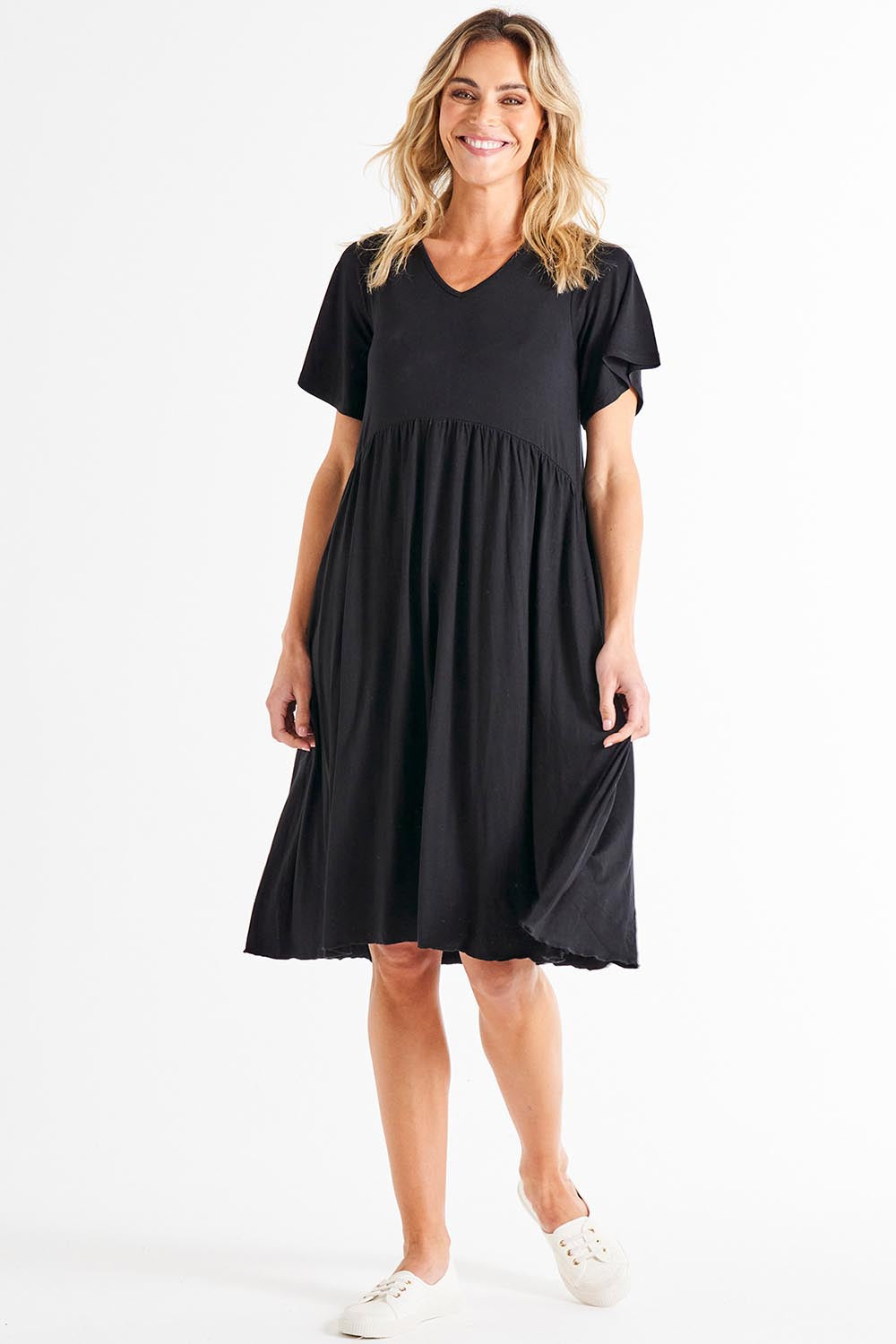 A model wearing the Donna Dress in colour Black (Black), from the front, showing the whole outfit