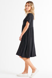 A model wearing the Donna Dress in colour Black (Black), from the front, showing the whole outfit