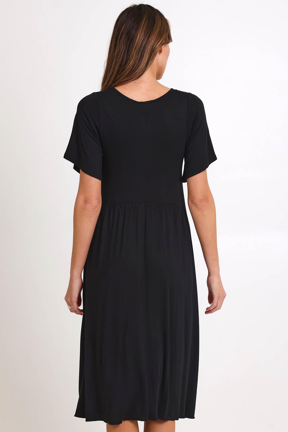 Model Madelinec wearing size 10 of the Donna Dress - Black in colour Black, from the back