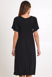 Model Madelinec wearing size 10 of the Donna Dress - Black in colour Black, from the back