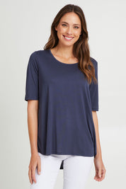Model Madeline wearing size 10 of the Maya Tee in colour Dustyblue (Blue), from the front, cropped image