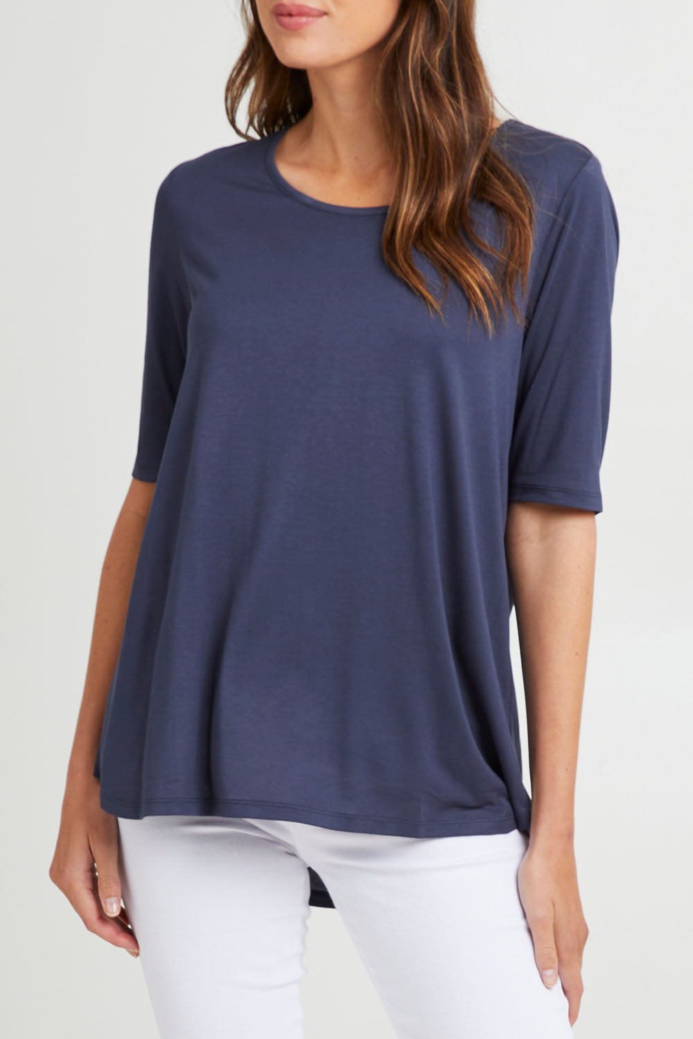 Model Madeline wearing size 10 of the Maya Tee in colour Dustyblue (Blue), from the front, cropped image