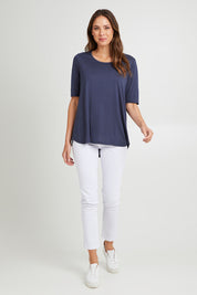 Model Madeline wearing size 10 of the Maya Tee in colour Dustyblue (Blue), from the front, showing the whole outfit