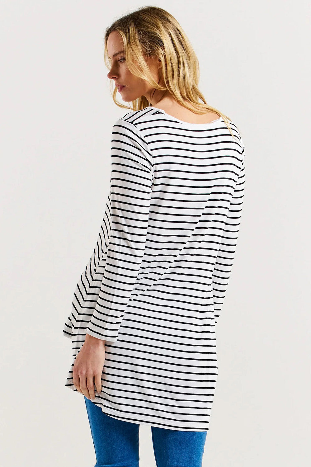 A model wearing the Cairo Tunic Bamboo Top in colour Monostripe (White), from the back