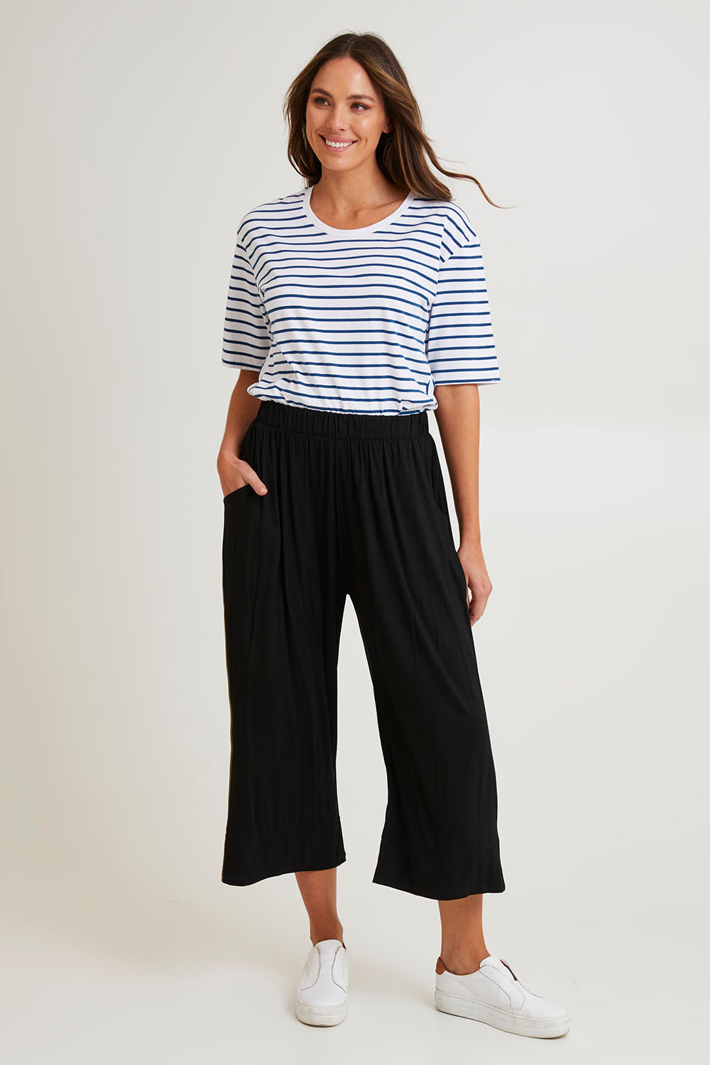 Model Madeline wearing size 10 of the Astrid Bamboo Wide Leg Pant in colour Black (Black), from the front, showing the whole outfit