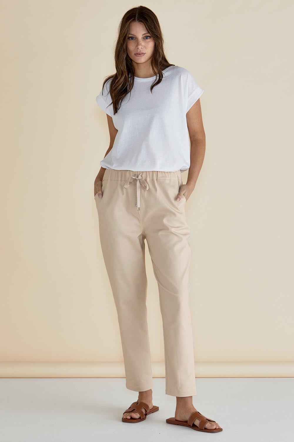 A model wearing the Kenzie Cotton Blend Jogger in colour Cream, from the front, showing the whole outfit