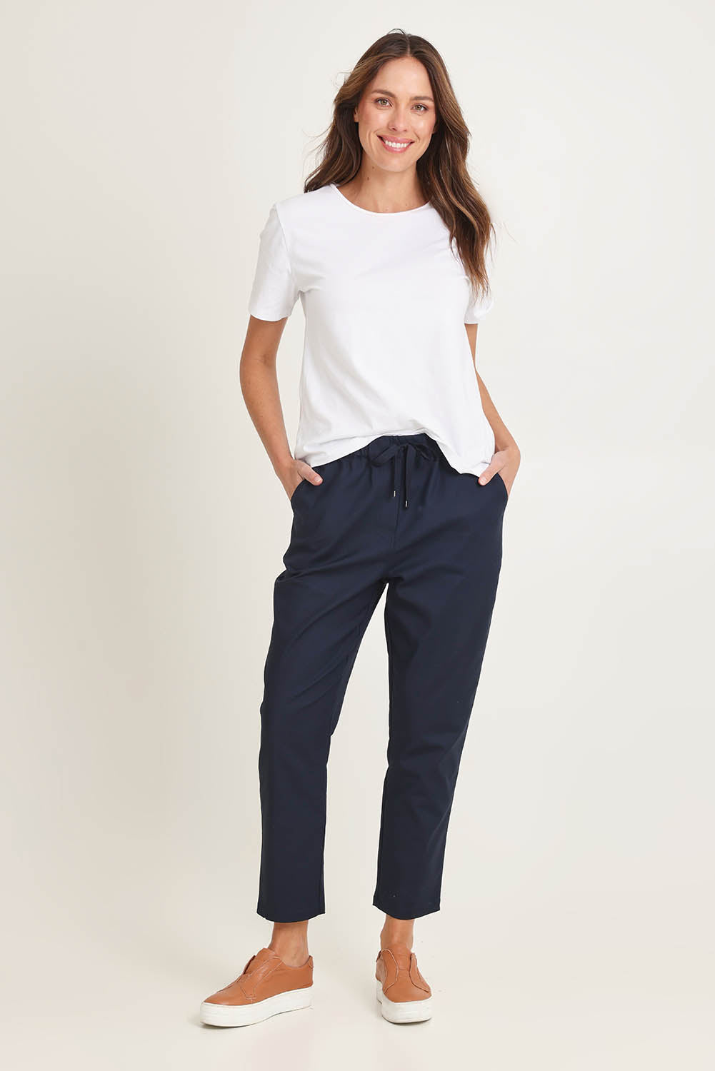 Model Madeline wearing size 10 of the Kenzie Cotton Blend Jogger in colour Navy (Blue), from the front, showing the whole outfit