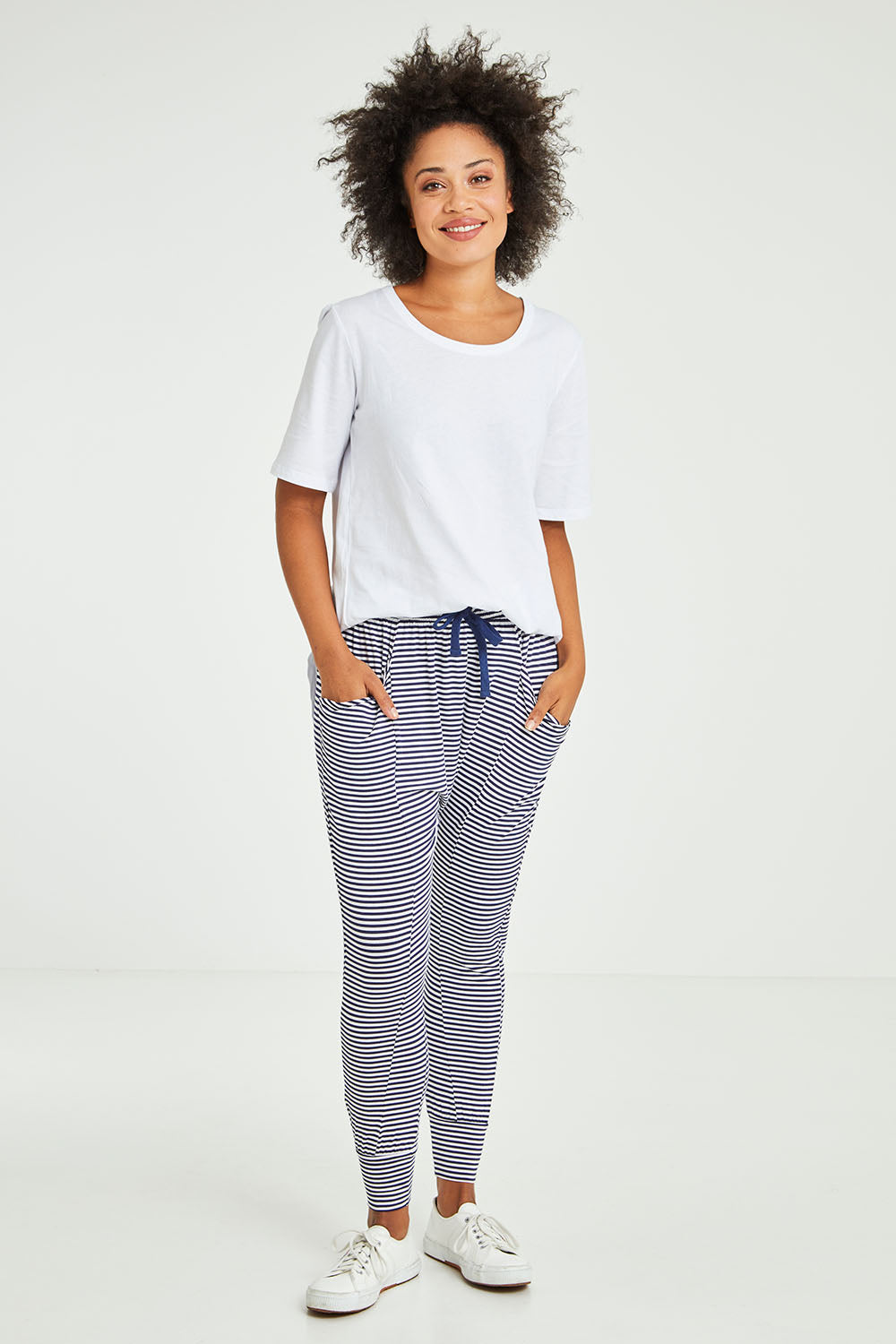 Model Olivia wearing size 10 of the Barcelona Pant in colour Navystripe (Blue), from the front, showing the whole outfit