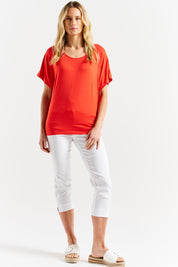 A model wearing the Maui Tee in colour Flamered (Red), from the front, showing the whole outfit