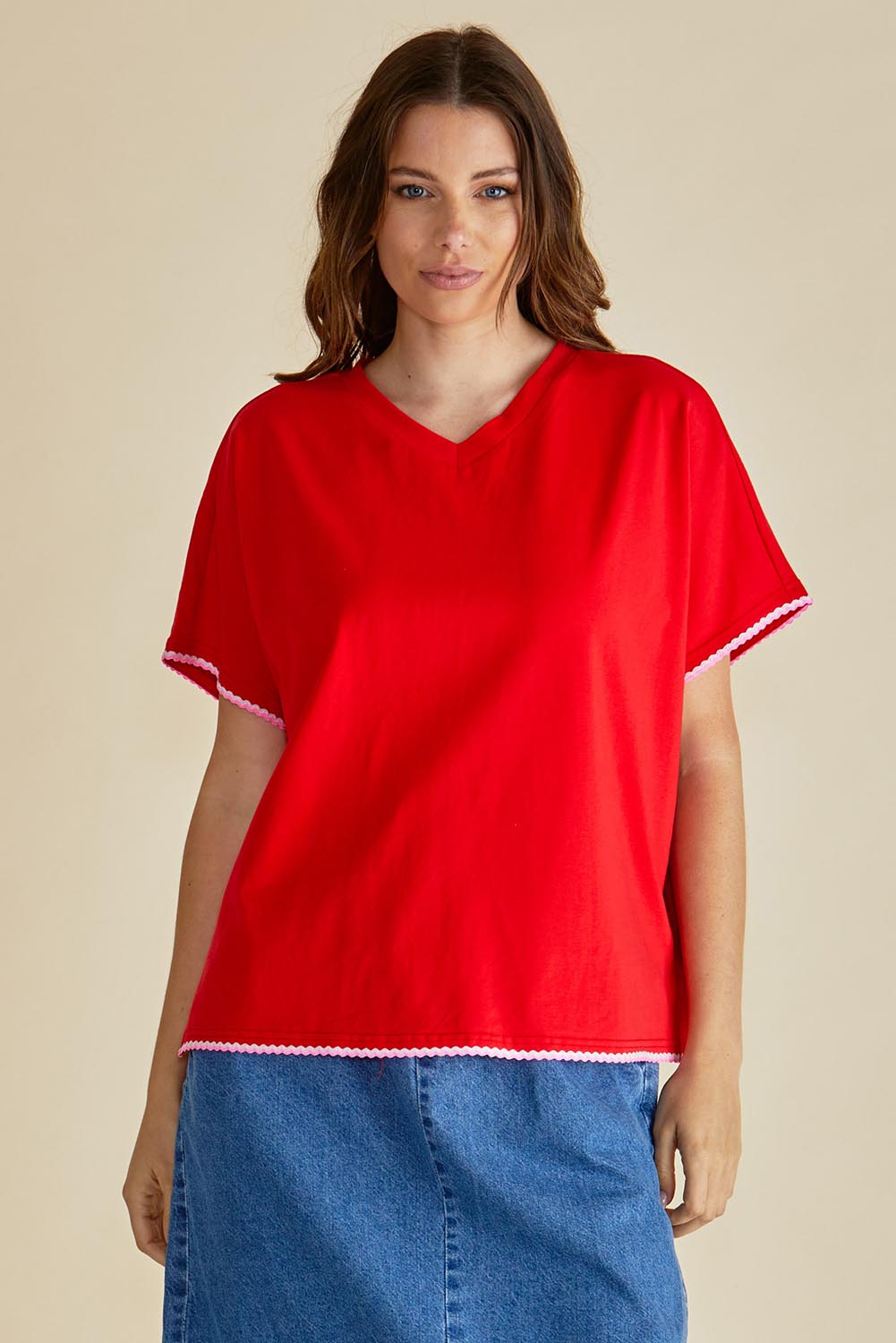 A model wearing the Avalon Cotton Tee in colour Red (Red), from the front, cropped image
