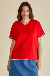A model wearing the Avalon Cotton Tee in colour Red (Red), from the front, cropped image