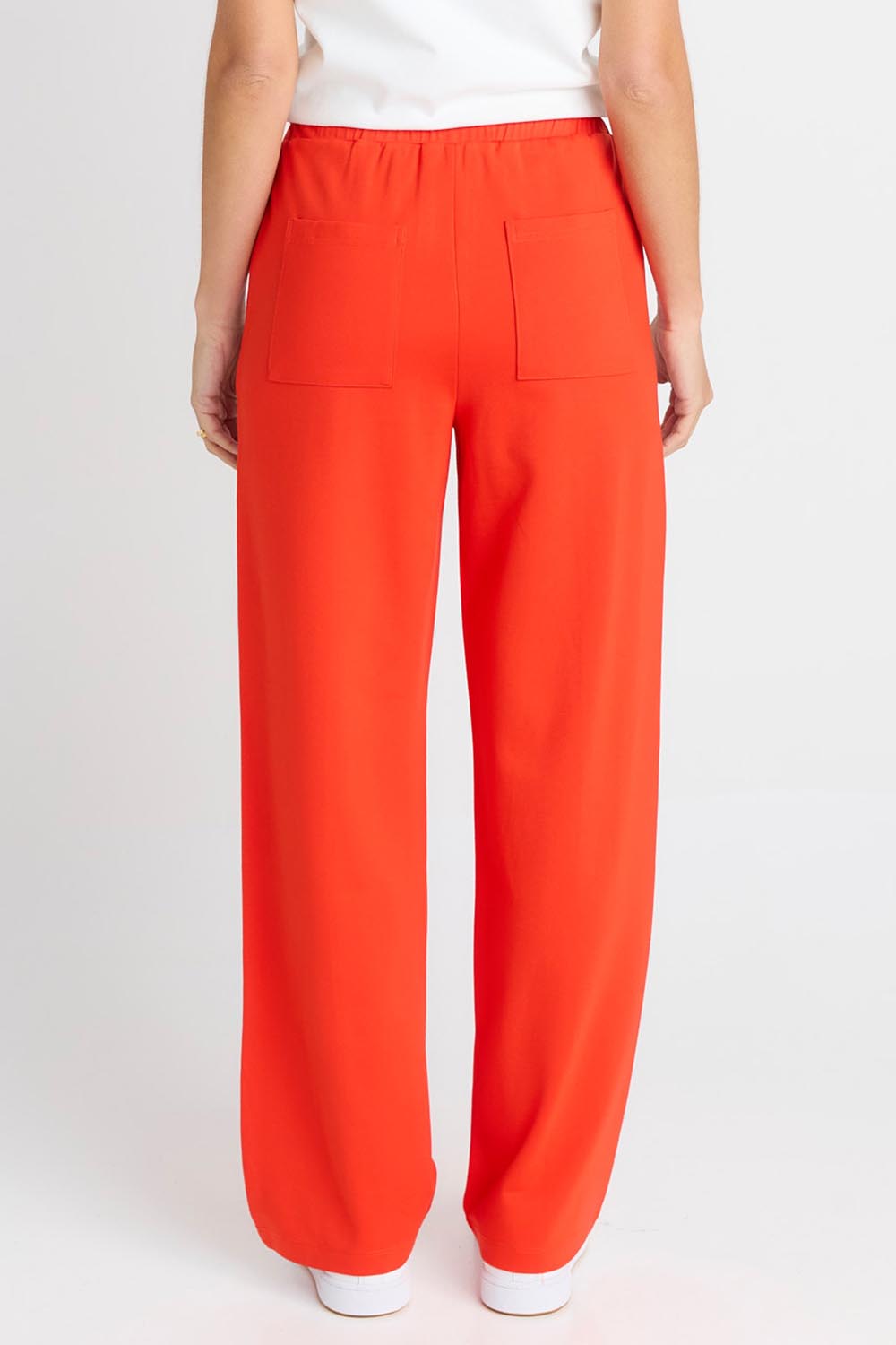 Model Genericm wearing size sample of the Jamie Track Pant – Tomato in colour Tomato, from the back