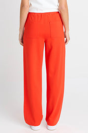 Model Genericm wearing size sample of the Jamie Track Pant – Tomato in colour Tomato, from the back