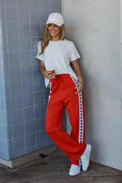 Model Genericm wearing size sample of the Jamie Track Pant – Tomato in colour Tomato, from the front