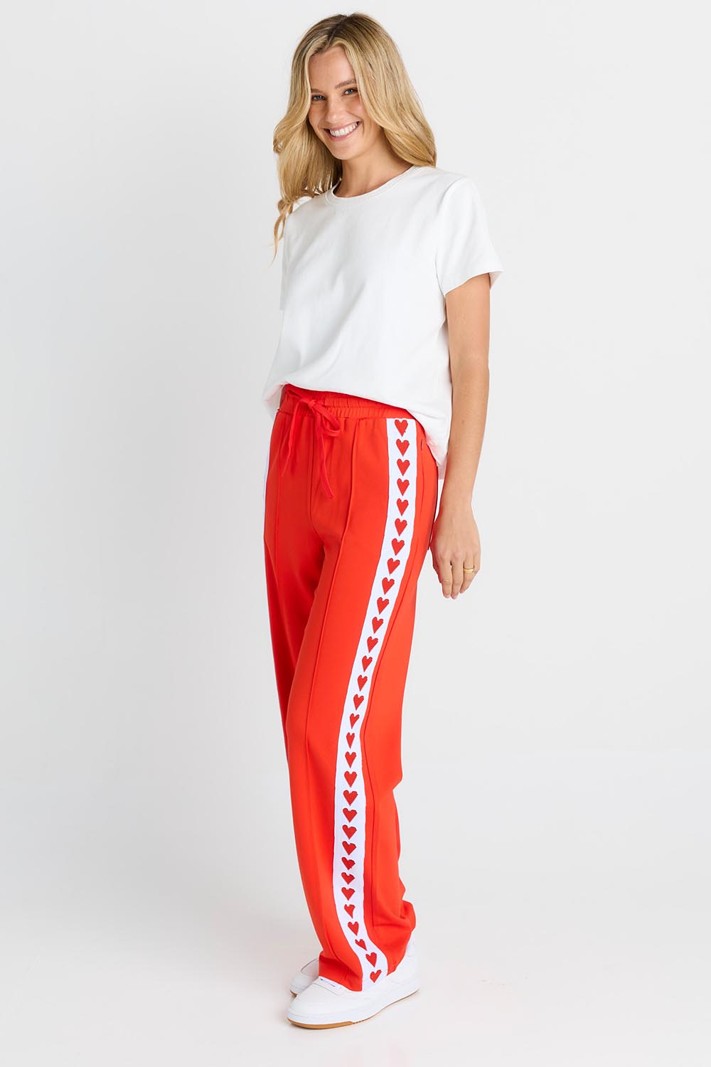 Model Genericm wearing size sample of the Jamie Track Pant – Tomato in colour Tomato, from the front